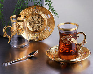 Gold tea set with a glass mug and teacup.